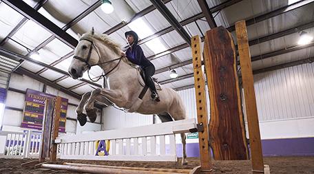 photo of woman jumping horse