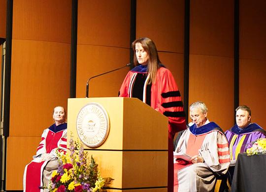 woman in red robe at podium