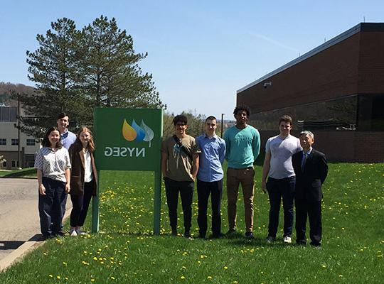 group of people standing in front of sign outside building